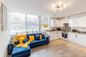a living room with a blue couch and a kitchen at Modern flat in central golders green in London