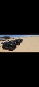 un groupe de véhicules militaires assis dans le sable dans l'établissement Excursion dakhla tour, à Dakhla