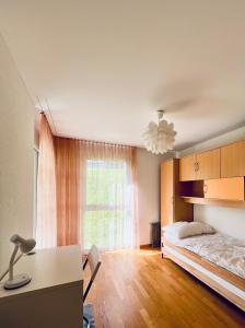sypialnia z łóżkiem, biurkiem i oknem w obiekcie Casa Luna A - CharmingStay w mieście Flumserberg