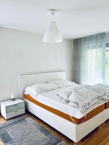 FlumserbergにあるCasa Luna A - CharmingStayの白いベッドルーム(大型ベッド1台、窓付)