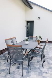 einen Tisch und Stühle auf einer Terrasse in der Unterkunft Domek na wyłączność - Borówkowa. SAUNA 
