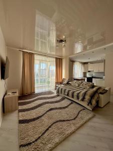 ein großes Schlafzimmer mit einem großen Bett und einem großen Fenster in der Unterkunft Apartment Ivashchenka 1a in Luzk