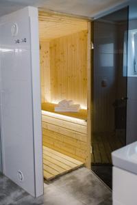 eine Sauna im Bad mit einer Holzwand in der Unterkunft Domek na wyłączność - Borówkowa. SAUNA 