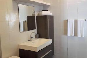 ein Badezimmer mit Waschbecken, Spiegel und Handtüchern in der Unterkunft Sylvie Resort Curaçao in Willemstad + 21 Fotos