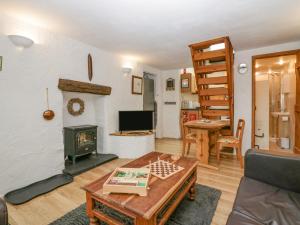 - un salon avec une cheminée et une table dans l'établissement Old Peat Cottage, à Grizebeck