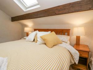 - une chambre avec un grand lit et des oreillers blancs dans l'établissement Old Peat Cottage, à Grizebeck