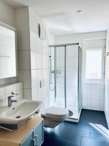 y baño con aseo, lavabo y ducha. en Casa Luna A - CharmingStay, en Flumserberg