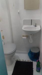a bathroom with a white toilet and a sink at Antonia Hospedaria 1 in Búzios