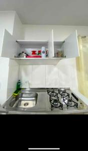 a kitchen with a sink and a stove at Apê 202 in Brasilia