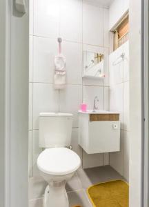 a white bathroom with a toilet and a sink at Apê 202 in Brasilia