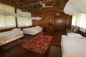 a large room with two beds and a rug at Sandoval Lake Lodge in Puerto Maldonado