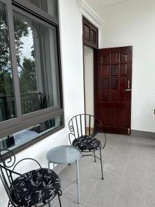 a patio with two chairs and a table and a window at THIÊN NGA HOTEL in Buôn Alê (1)