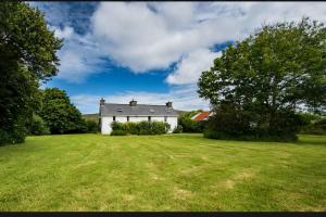 a large white house with a large yard at 3 bed cottage in Ahakista West cork in Ahakista