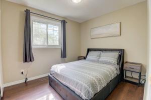 a bedroom with a bed and a window at Newly Renovated Detached Home in Brampton