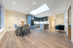 cocina y comedor con mesa y sillas en Candler Mews, en Twickenham