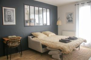 a bedroom with a bed and a table and a window at La Belle Epoque - Proche Gare - Parking Gratuit in Angoulême +10 photos