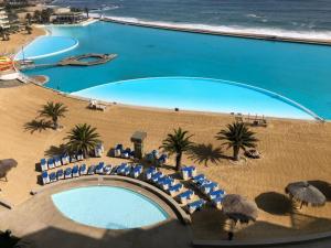 an overhead view of a pool with chairs and the beach at San Alfonso del Mar 802 in Algarrobo
