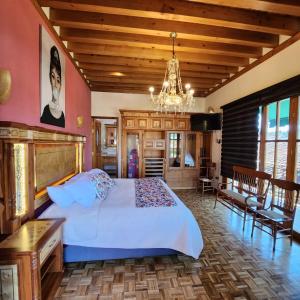 a bedroom with a large bed and a chandelier at La Casa Baez in Pátzcuaro