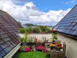 a balcony with a table and chairs and plants at Carnethic Penthouse in Fowey