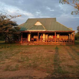 une grande maison en bois avec un toit vert dans l'établissement Narasha Homestay - Maasai Mara, à Talek