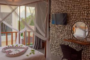 a bedroom with a bed and a mirror and a balcony at Sandy Heaven Maldives in Gulhi