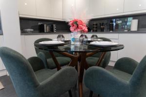 a dining room with a table and four chairs at 4 bedroom home - free parking by Ideel Apartments in Milton Keynes in Wolverton
