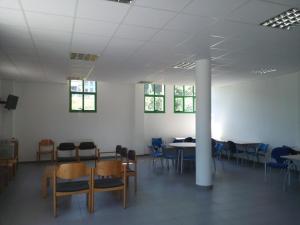 ein Zimmer mit Tischen und Stühlen in einem Gebäude in der Unterkunft Albergue El Floran in Blimea