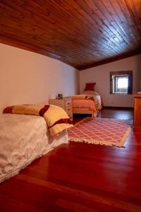 a bedroom with two beds and a wooden ceiling at Casa Sobreira da Silva - Alojamento Local in Almeida
