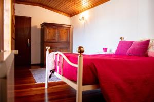 a bedroom with a bed with a red bedspread at Casa Sobreira da Silva - Alojamento Local in Almeida