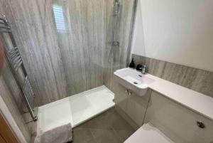 y baño con ducha, aseo y lavamanos. en Silver Stag Properties, 3 BR Sandstone Lodge, 