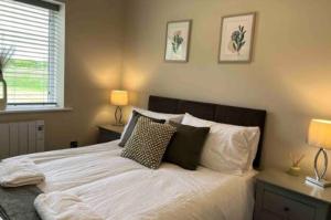 - une chambre avec un lit doté de draps et d'oreillers blancs dans l'établissement Silver Stag Properties, 3 BR Sandstone Lodge, 