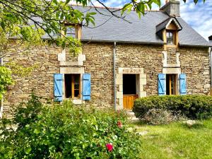 uma velha casa de pedra com persianas azuis em LA MAISON BLEUE,authenticité, nature, simplicité, 2-5 personnes, Moëlan sur Mer em Moëlan-sur-Mer