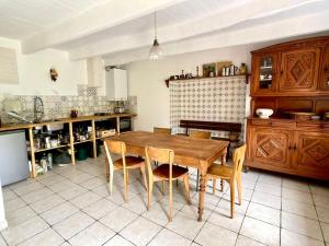 uma cozinha com uma mesa de madeira e cadeiras em LA MAISON BLEUE,authenticité, nature, simplicité, 2-5 personnes, Moëlan sur Mer em Moëlan-sur-Mer