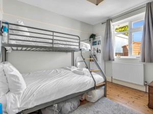ein Schlafzimmer mit einem Etagenbett und einem Fenster in der Unterkunft Pass the Keys Little Haven A stunning Bungalow in Minnis Bay in Birchington