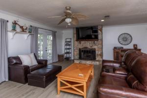 a living room with leather furniture and a fireplace at Cypress Landing in Pass Christian