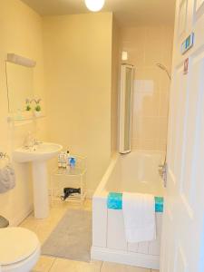 y baño con bañera, lavabo y aseo. en Valentia Skellig Rooms, en Isla de Valentia