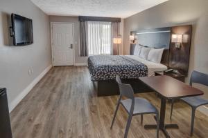 a hotel room with a bed and a table and chairs at Econo Lodge on the River Sevierville-Pigeon Forge in Sevierville