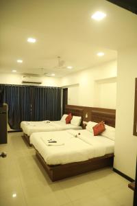 a hotel room with three beds in a room at Hotel Shiv Leela Grand in Mumbai