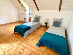 um quarto com 2 camas e piso em madeira em LA MAISON BLEUE,authenticité, nature, simplicité, 2-5 personnes, Moëlan sur Mer em Moëlan-sur-Mer