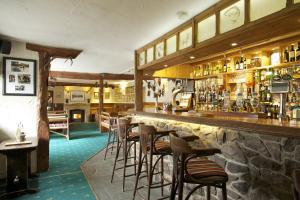 a bar with a bunch of bar stools at Exmoor White Horse Inn in Exford