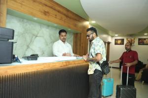 two men standing at a counter in an office at Hotel Shiv Leela Grand in Mumbai