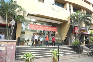 Hotel Shiv Leela Grand في مومباي: مجموعة أشخاص واقفين أمام مبنى