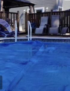 una piscina azul con sillas y una casa en Chalet chez Divine!, en Trois-Rivières
