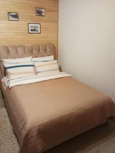 sypialnia z dużym łóżkiem z drewnianym zagłówkiem w obiekcie Jurgvita w Połądze
