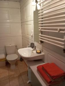a bathroom with a white sink and a toilet at Jurgvita in Palanga