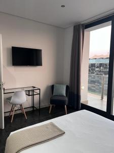 Dormitorio con cama, escritorio y TV en @ORRIE Apartments Infinite, en Johannesburgo