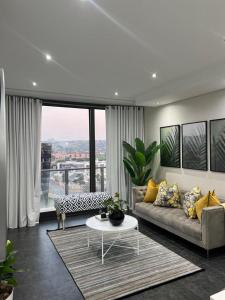 un soggiorno con divano e tavolo di @ORRIE Apartments Infinite a Johannesburg