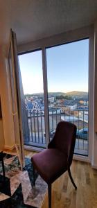 a living room with a chair and a large window at Apartman N&E in Bjelašnica