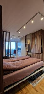 um quarto com uma cama grande e uma cabeceira em madeira em Apartman N&E em Bjelašnica