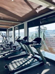 a gym with a row of cardio machines in front of windows at @ORRIE Apartments Infinite in Johannesburg